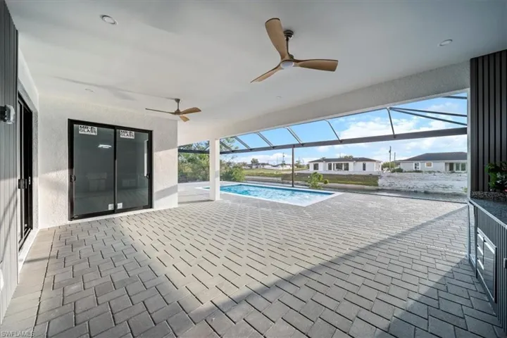 Swimming pool featuring ceiling fan, a patio, and a lanai
