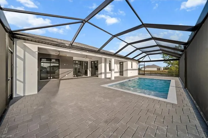 Swimming pool with a patio, a ceiling fan, and a lanai