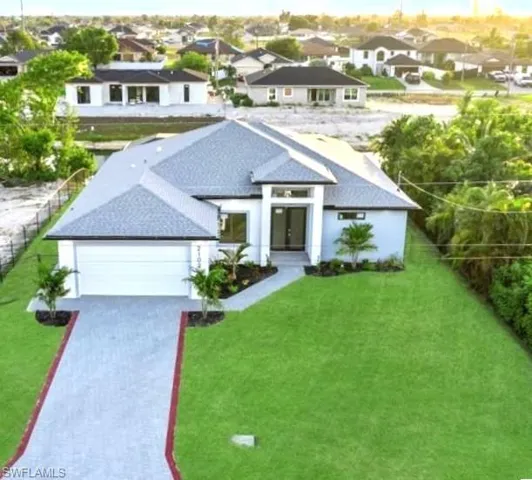 View of front of property with a residential view, decorative driveway, a front yard, a shingled roof, and an attached garage