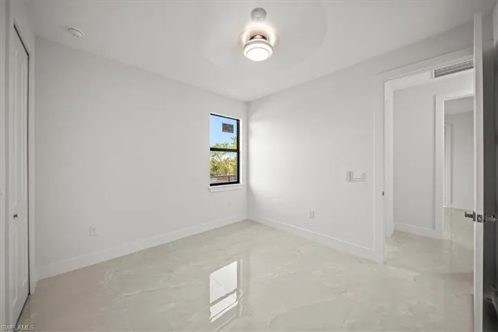 Unfurnished bedroom with light marble finish flooring, baseboards, and a closet