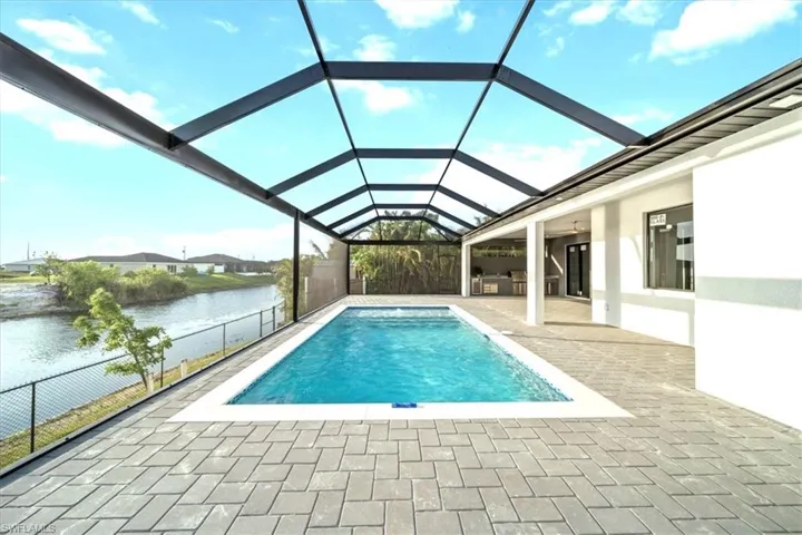 Swimming pool with a water view, a patio, and a lanai