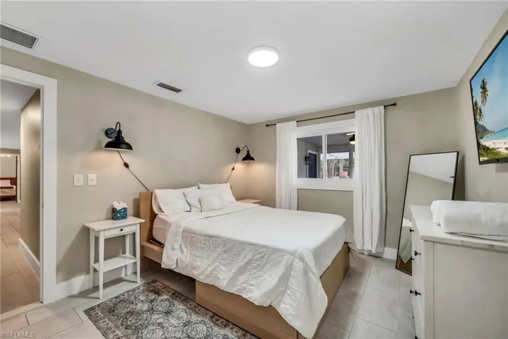 1 Guest bedroom  featuring limewash paint and tile flooring