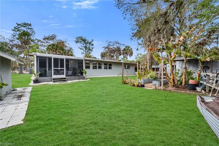 Back of house featuring a lawn, a sunroom, and a patio