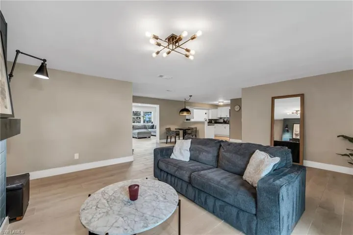 Family room  featuring light wood plank porcelain tile flooring and a fireplace