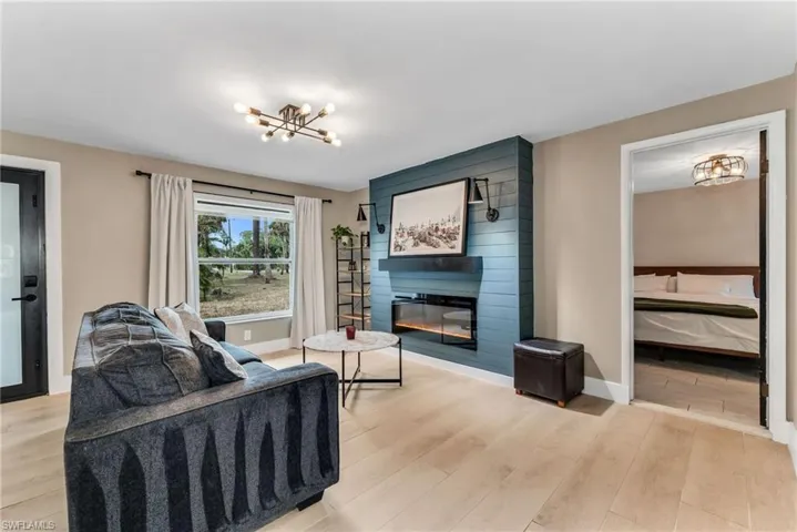Family room  featuring light wood plank porcelain tile flooring and a fireplace