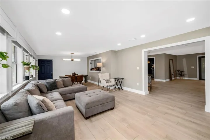 Living area featuring light wood plank porcelain tile flooring and recessed lighting