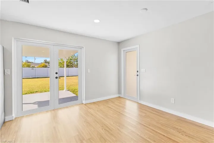 Spare room featuring french doors, light wood-style flooring, and recessed lighting
