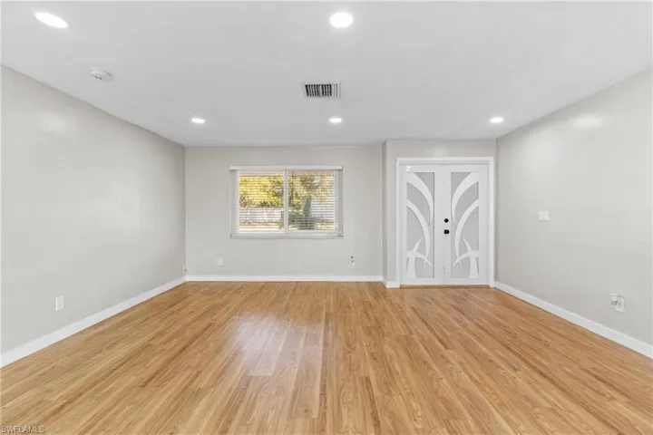 Empty room with recessed lighting and light wood-style floors