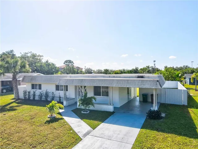 View of front of property featuring a front lawn, stucco siding, and driveway