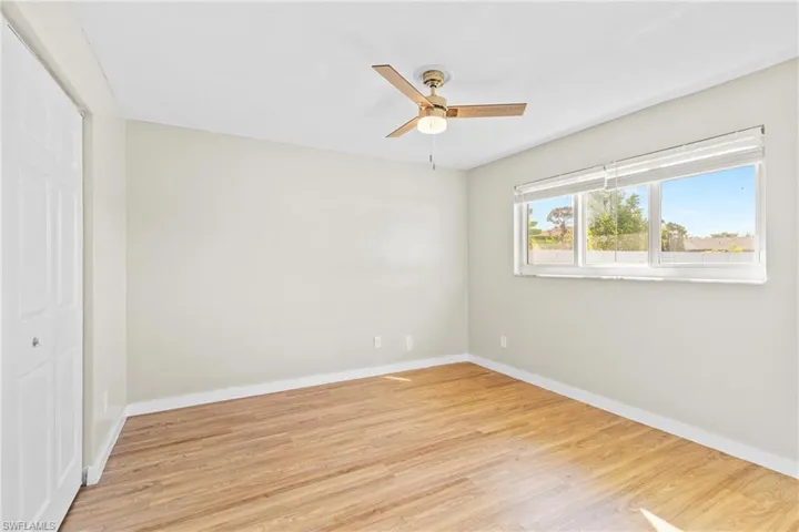 Unfurnished bedroom featuring light wood finished floors, a closet, and a ceiling fan