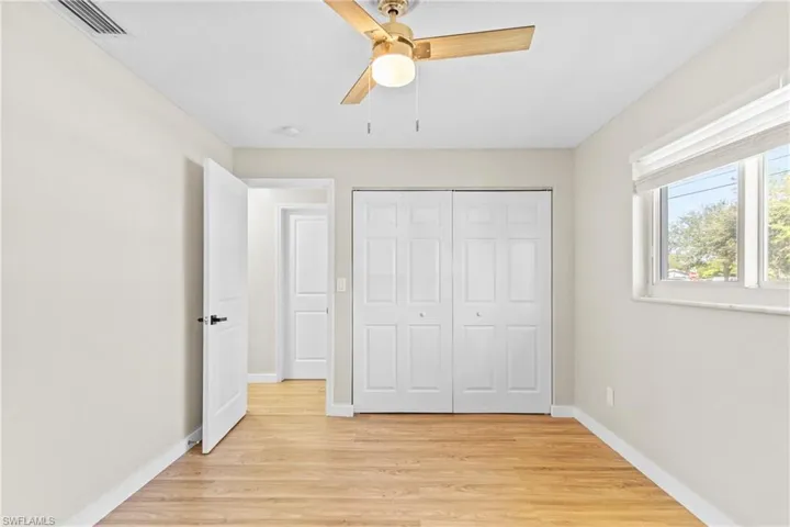 Unfurnished bedroom featuring light wood finished floors, a closet, and a ceiling fan