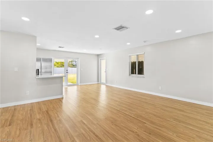 Unfurnished living room with recessed lighting, light wood-style flooring, and french doors