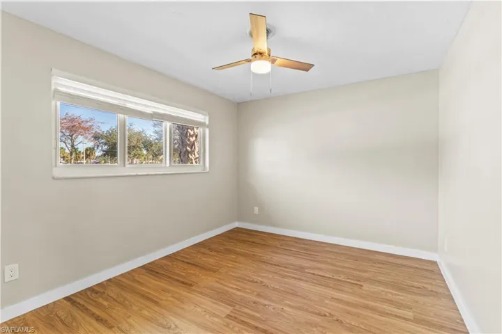 Empty room with light wood-style floors and a ceiling fan