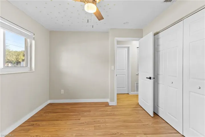 Unfurnished bedroom with light wood-style flooring, ceiling fan, and a closet