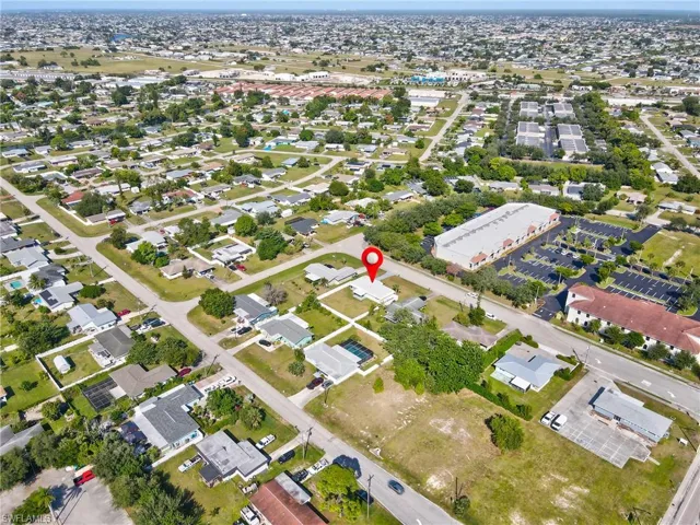 Aerial view of property and surrounding area featuring nearby suburban area