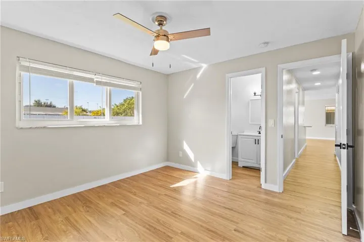 Unfurnished bedroom with light wood-type flooring, a ceiling fan, and ensuite bath