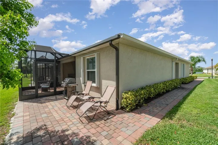 View of property exterior, lawn, patio, sidewalk and screened enclosure