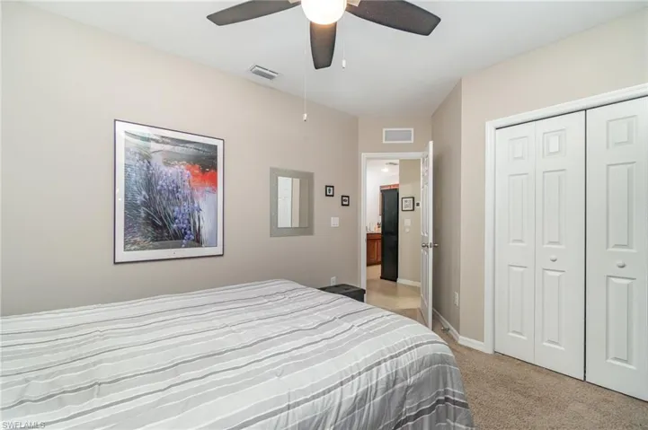 Guest bedroom carpeted with ceiling fan and a closet
