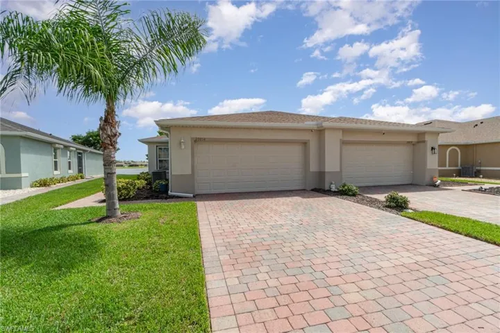 View of front villa showing the  cooling unit,  garage, and front yard