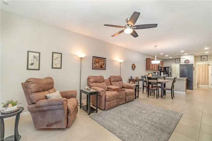 Living room with ceiling fan and light tile patterned floors