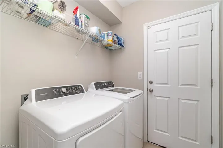 Washroom with washing machine and dryer - screen door to the garage