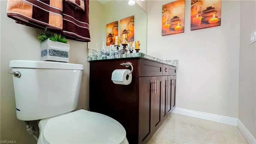 Bathroom featuring tile patterned flooring, toilet, and vanity