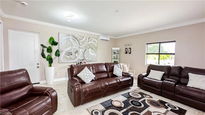 Tiled living room featuring a wall mounted air conditioner and crown molding