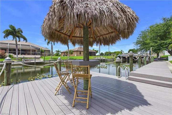 Waterfront composite decking featuring a tiki hut, dock, and boat cleats