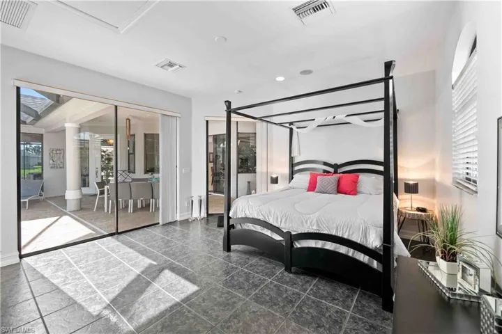 Spacious room featuring large format tile flooring and extensive sliding glass doors opening to a covered patio