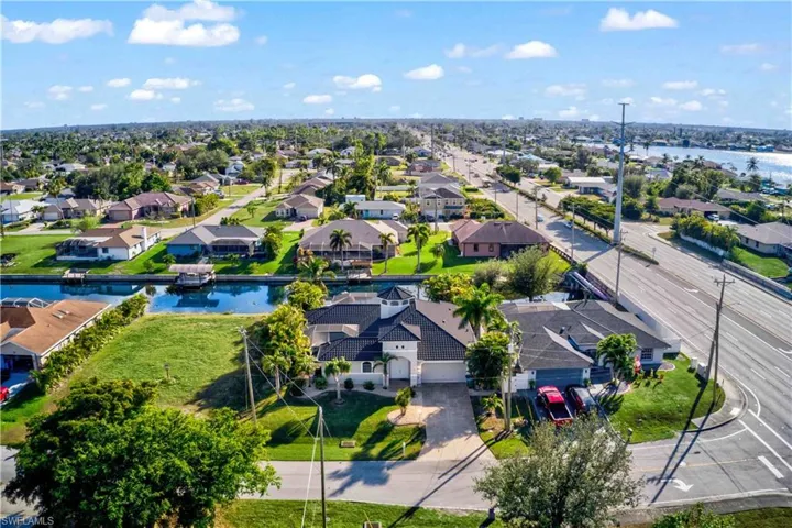 Canal-front property featuring a spacious lot, mature landscaping, and direct water access