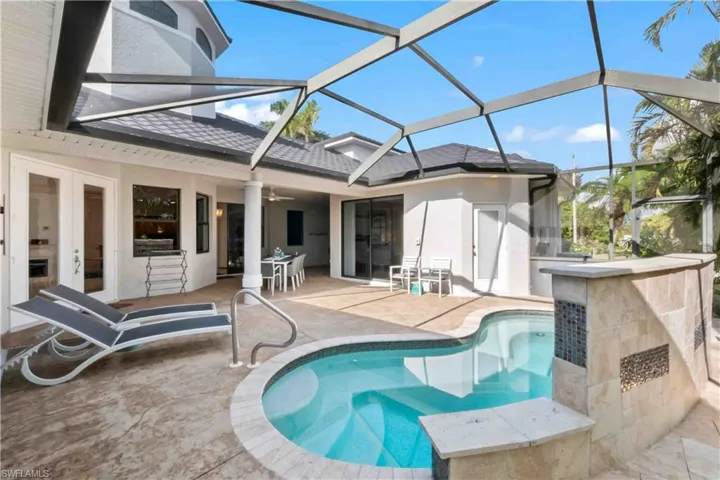 Screened courtyard with Spa, outdoor bar with stone veneer, and textured concrete decking