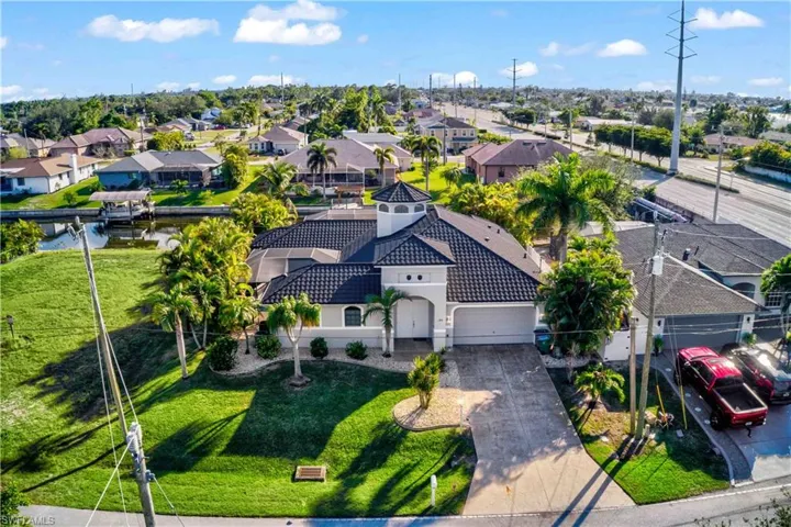 Mediterranean-style residence featuring a tile roof, turret architectural element, and a two-car garage
