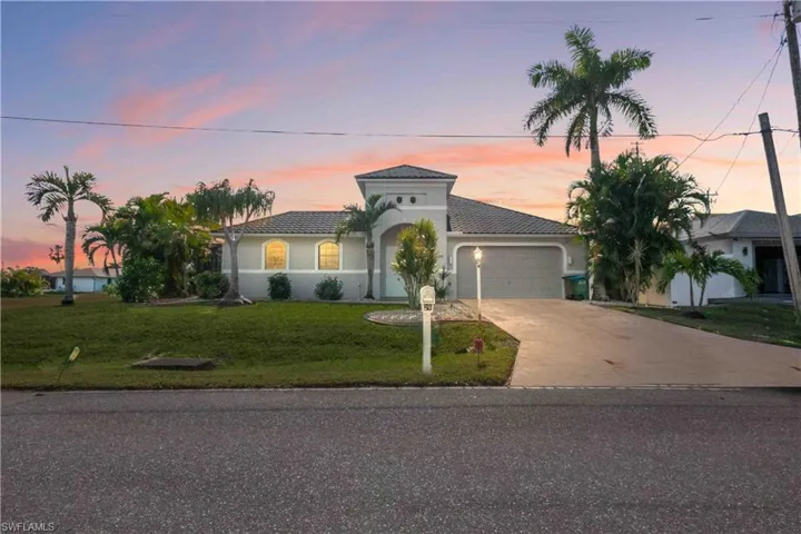 Mediterranean / spanish-style house with a garage and a lawn