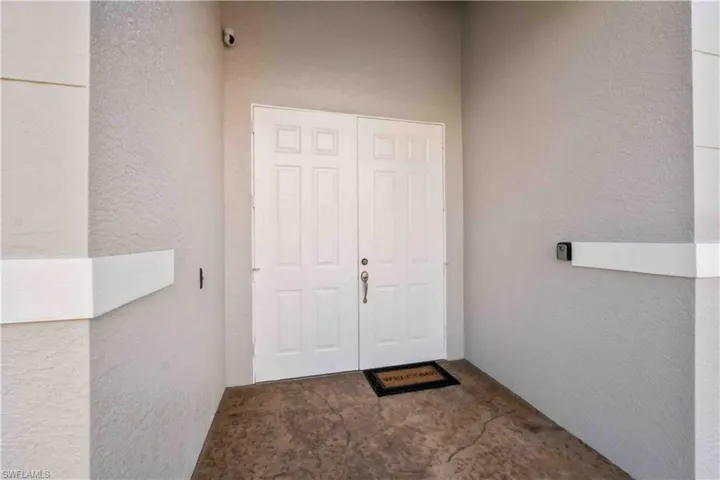 Entryway featuring a double door entry, textured walls, and a finished concrete floor