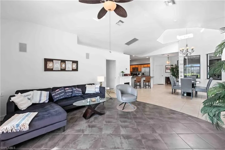 Vaulted ceilings with a ceiling fan and recessed lighting, contrasting tile flooring, and integrated wall speakers