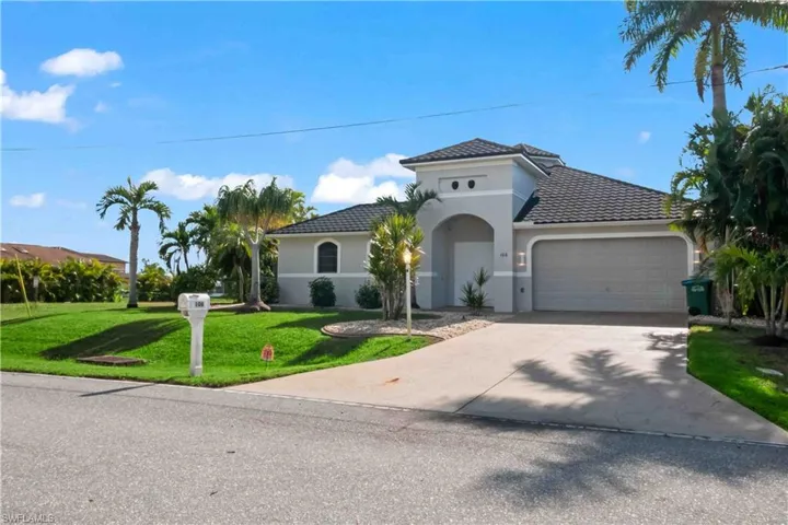 Mediterranean / spanish house with a front yard and a garage