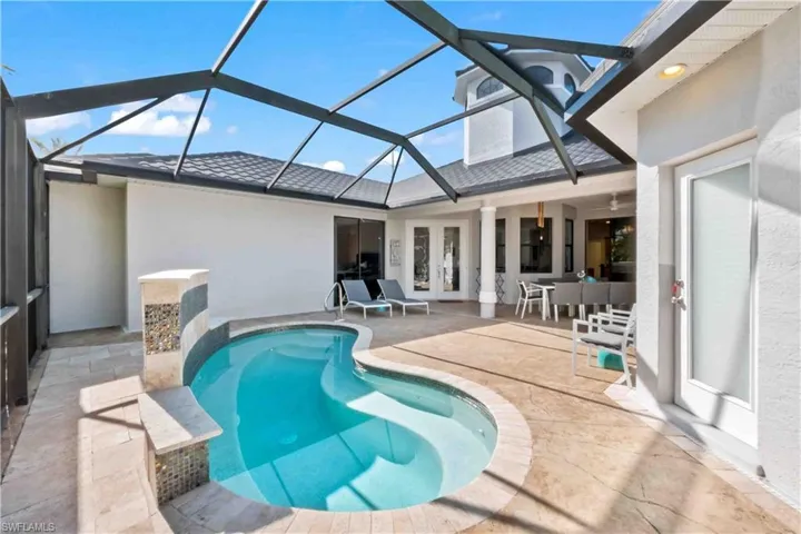 View of spa with glass enclosure, french doors, and a patio