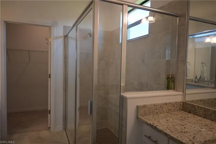Master Bathroom with vanity, a walk in closet, and a shower stall