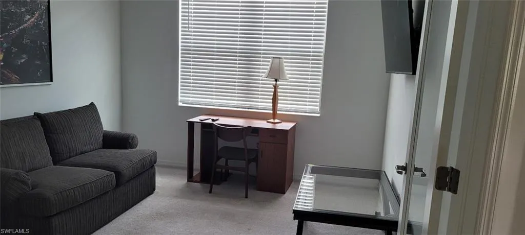 Sitting room featuring carpet flooring and a desk