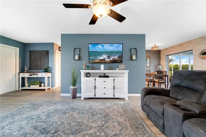 Living room with ceiling fan and hardwood / wood-style floors