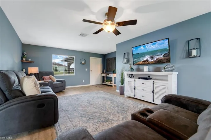 Living room featuring light wood-type flooring and ceiling fan