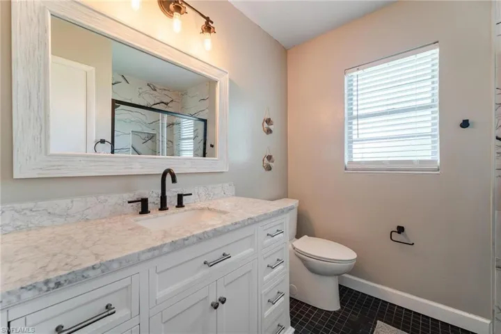 Bathroom featuring vanity, tile patterned floors, and toilet