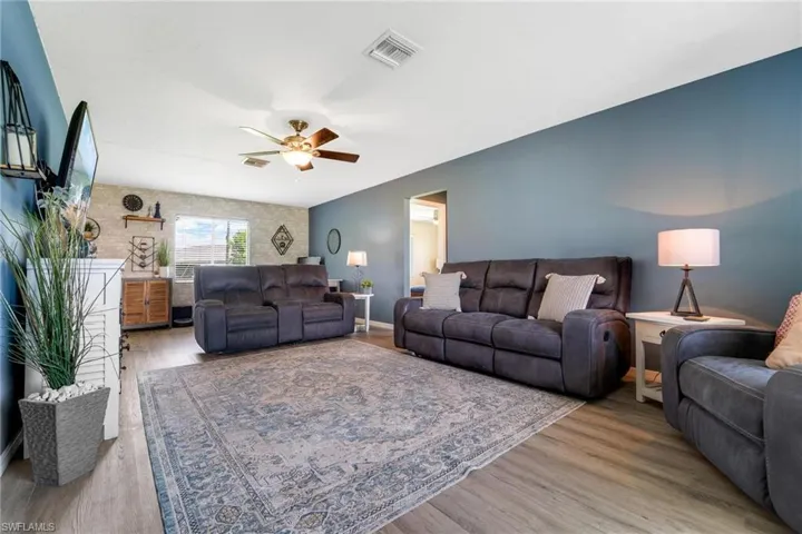 Living room with ceiling fan and light hardwood / wood-style flooring