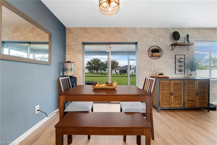 Dining room featuring light hardwood / wood-style flooring and brick wall