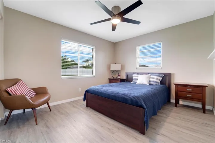 Bedroom featuring multiple windows, ceiling fan, and light wood-type flooring