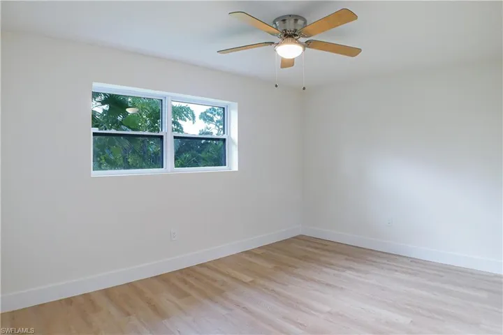 Unfurnished room with light hardwood / wood-style floors and ceiling fan