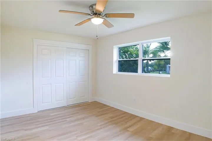 Unfurnished bedroom with ceiling fan, light wood-type flooring, and a closet