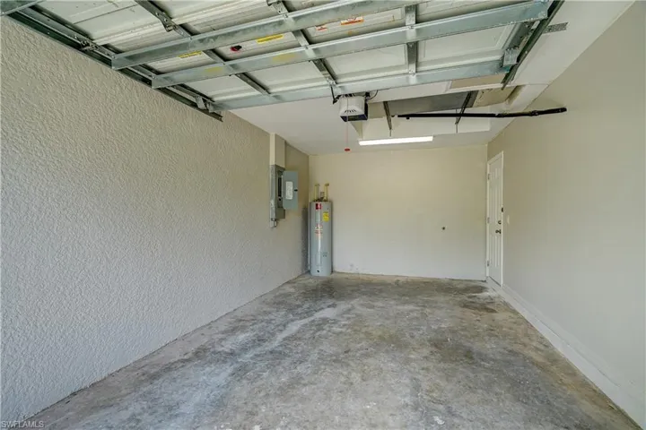 Garage featuring a garage door opener and water heater
