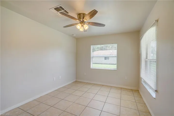 Unfurnished room with ceiling fan and light tile patterned floors