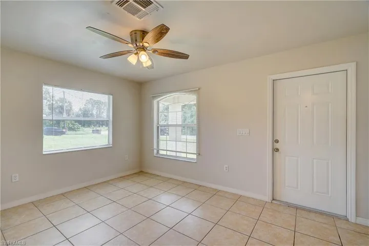 Tiled empty room featuring ceiling fan